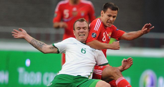 Glenn Whelan fends off Russia's Konstantin Zyryanov in Moscow.