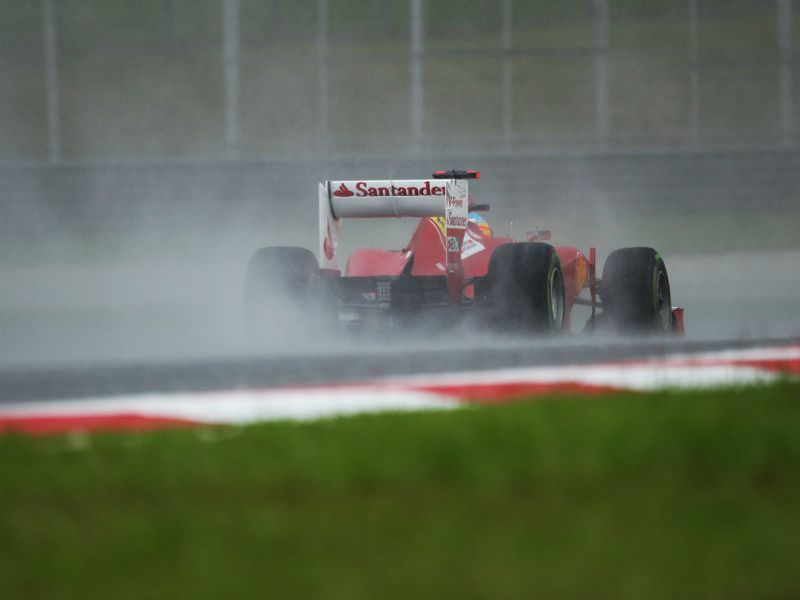 Fernando Alonso drives through the rain