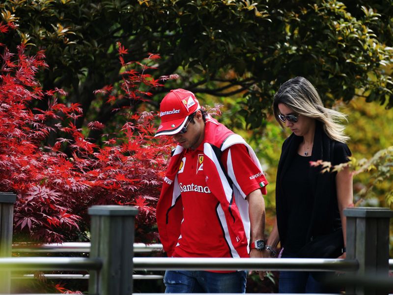 Felipe Massa makes his way to the pits with his wife