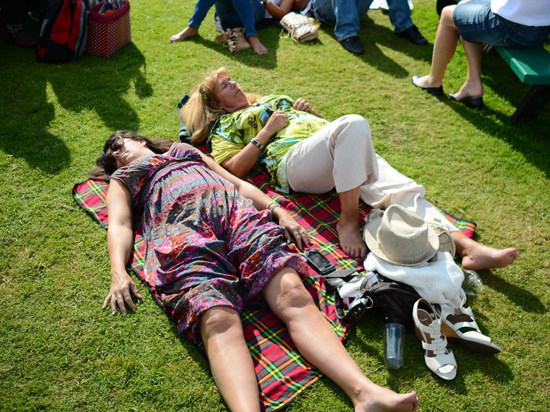 Some tennis fans enjoy a brief glimpse of the sun