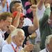 ...As Prince Harry, Lord Sebastian Coe and John Major cheer from the stands