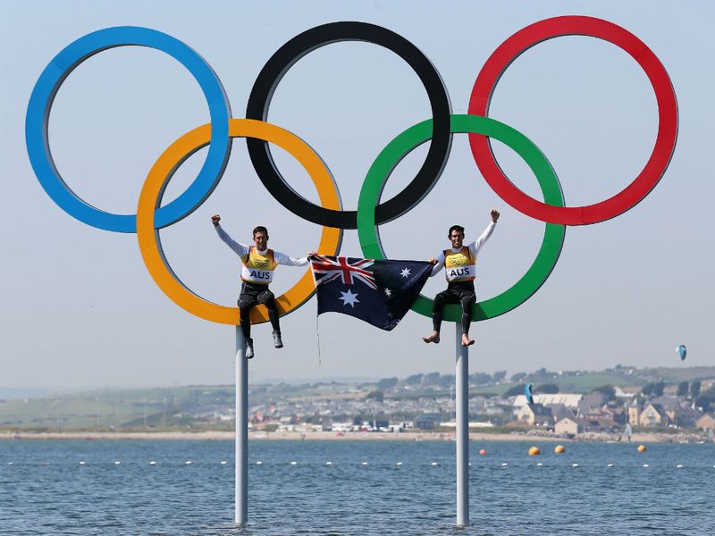 Australian gold medalists Mathew Belcher and Malcolm Page celebrate in the Olympic rings after their victory on the water.