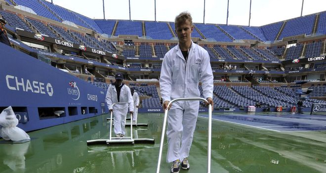 Court staff sweep away surface water at Flushing Meadows