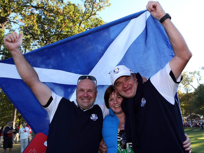 Paul Lawrie hoists the flag of Scotland and celebrates victory with his wife and caddie.