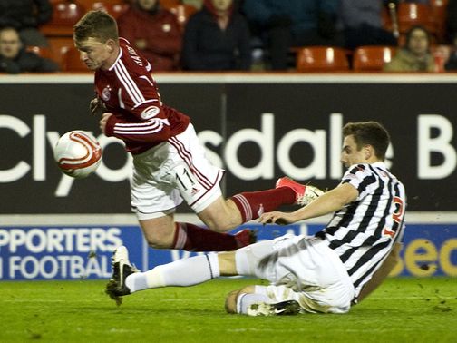 Jonny Hayes is challenged by Paul Dummett
