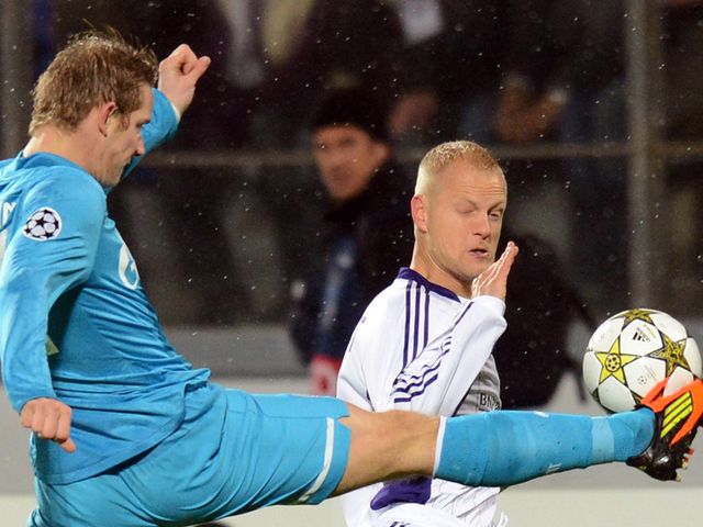 Hubocan knocks the ball away from Deschacht.