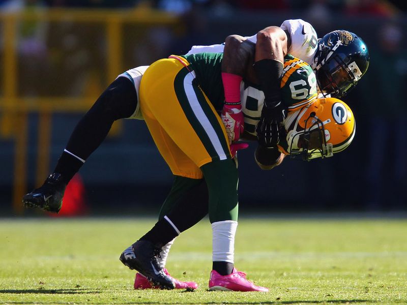 Packers running back Alex Green is tackled by Jthe Jaguars' Dawan Landry