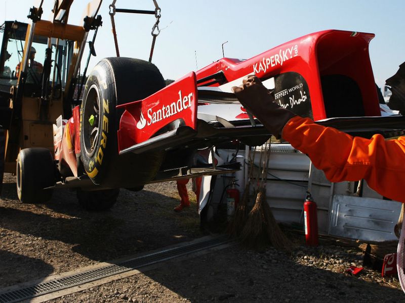 Alonso's car is lifted away