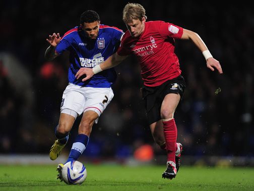 Carlos Edwards and Dan Harding battle for the ball