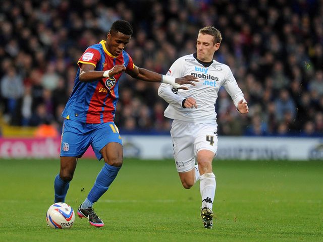Wilfried Zaha and Craig Bryson battle for the ball