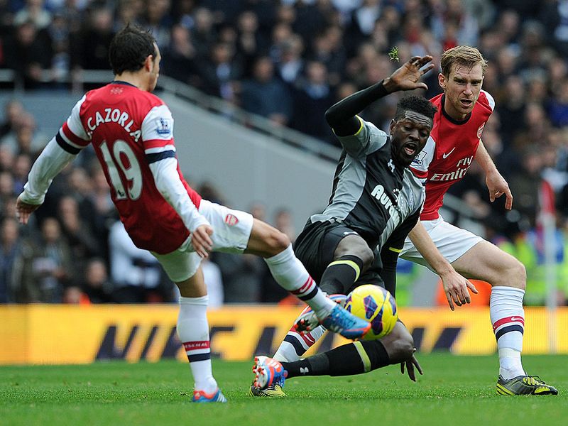 From hero to zero. Emmanuel Adebayor flies into a challenge, studs up, on Santi Cazorla.