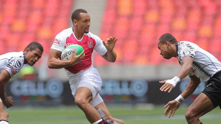 England star Dan Norton tries to avoid the Fiji defence at the Nelson Mandela Bay Sevens (Photo: IRB/Carl Fourie)