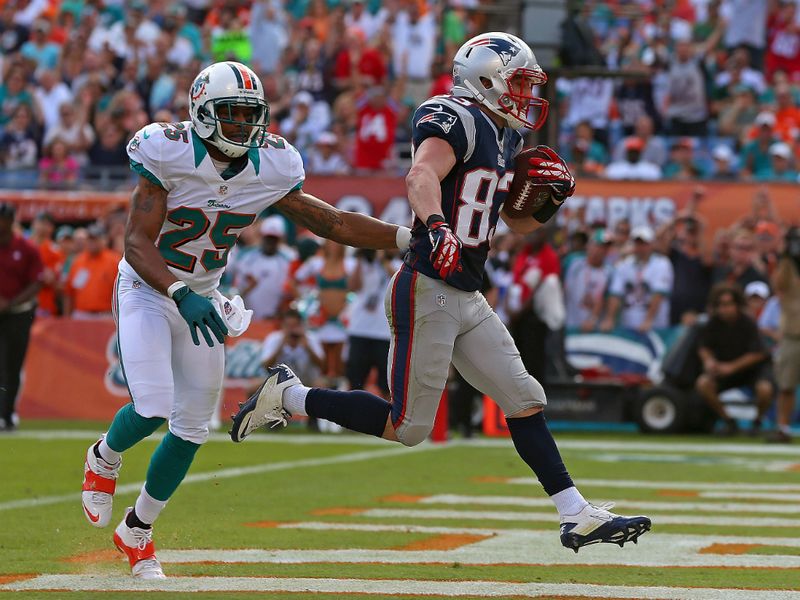 Wes Welker had 12 receptions as New England won in Miami to clinch their fourth consecutive AFC East title