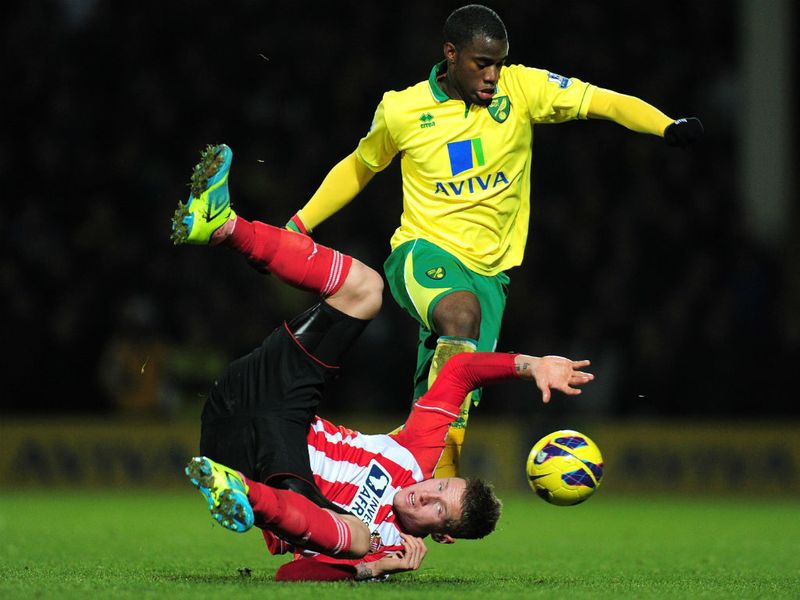 Connor Wickham falls to the ground under challenge by Sebastien Bassong as Norwich hold on