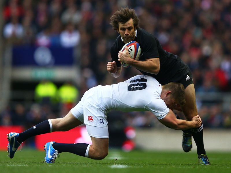 ...while the England No. 10 also played his part in defence, here tackling Conrad Smith