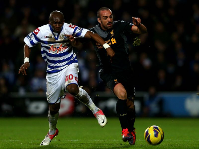 Jose Enrique is challenged by QPR's Stephane Mbia as the Reds go on to win 3-0 at Loftus Road