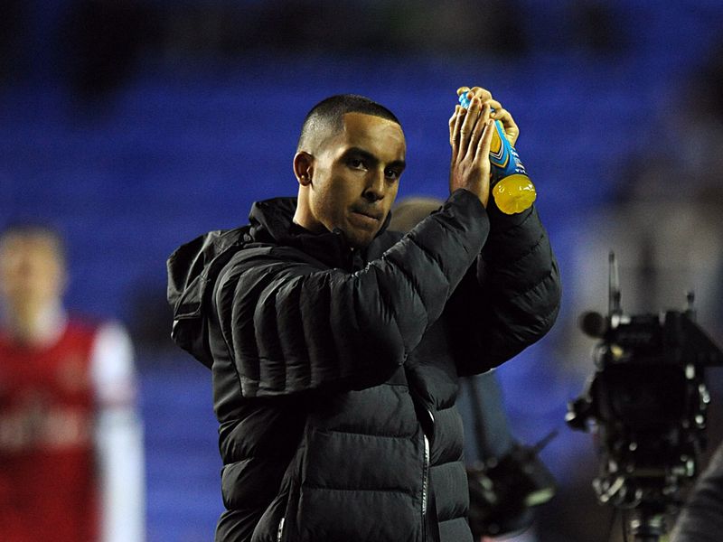 Walcott applauds the visiting supporters after the match as the Gunners celebrate moving up to fifth in the table