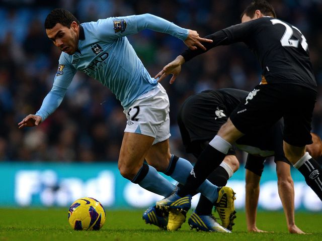 Carlos Tevez tries to wriggle his way through
