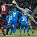 Wigan goalkeeper Mike Pollitt punches the ball clear in front of defender Tommy Elphick