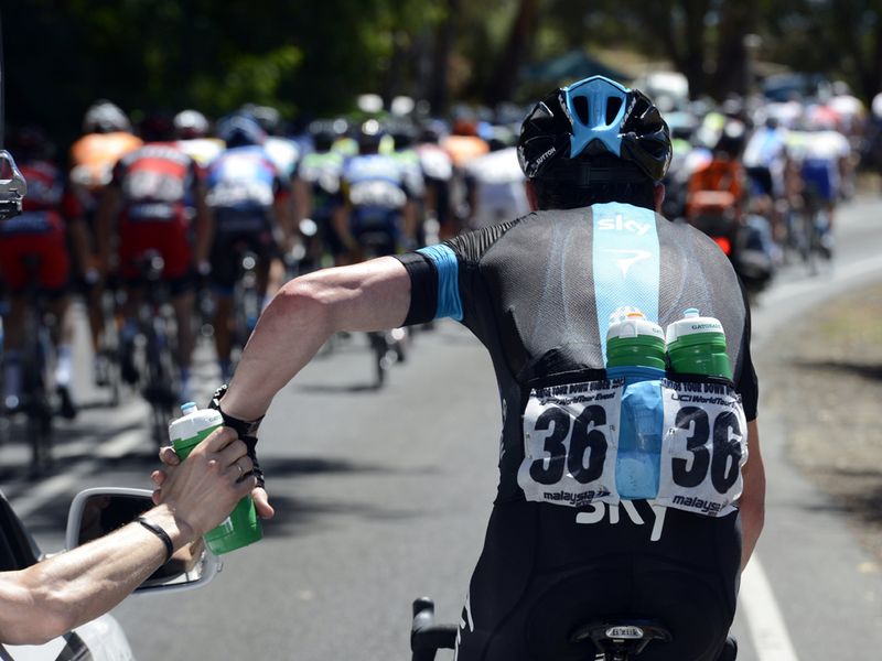 Sutton drops back to the car to pick up bidons on a sweltering day