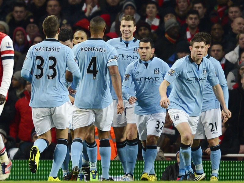 All smiles: Edin Dzeko is congratulated by team-mates after scoring