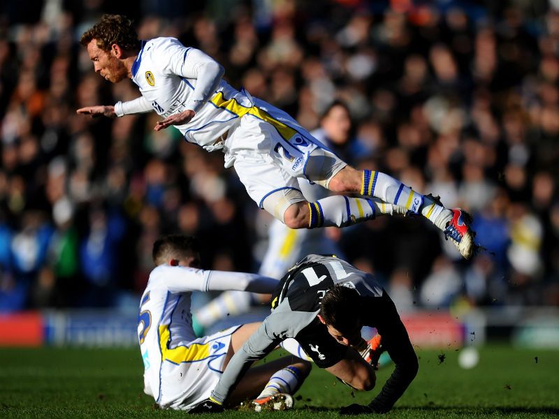 Cup battle: Paul Green of Leeds hurdles the grounded Gareth Bale