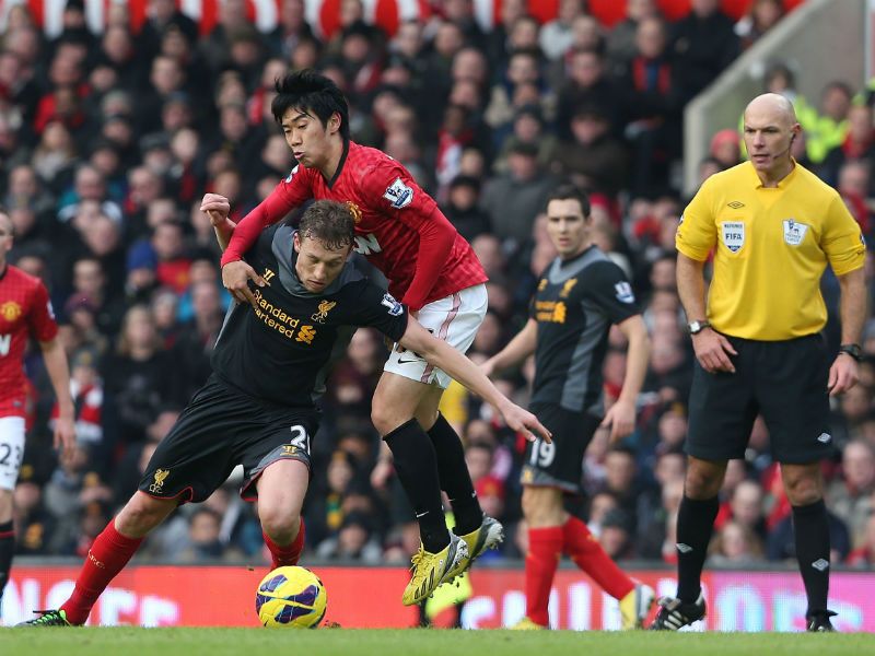 Midfield battle: Shinji Kagawa battles with Lucas Leiva as referee Howard Webb watches on