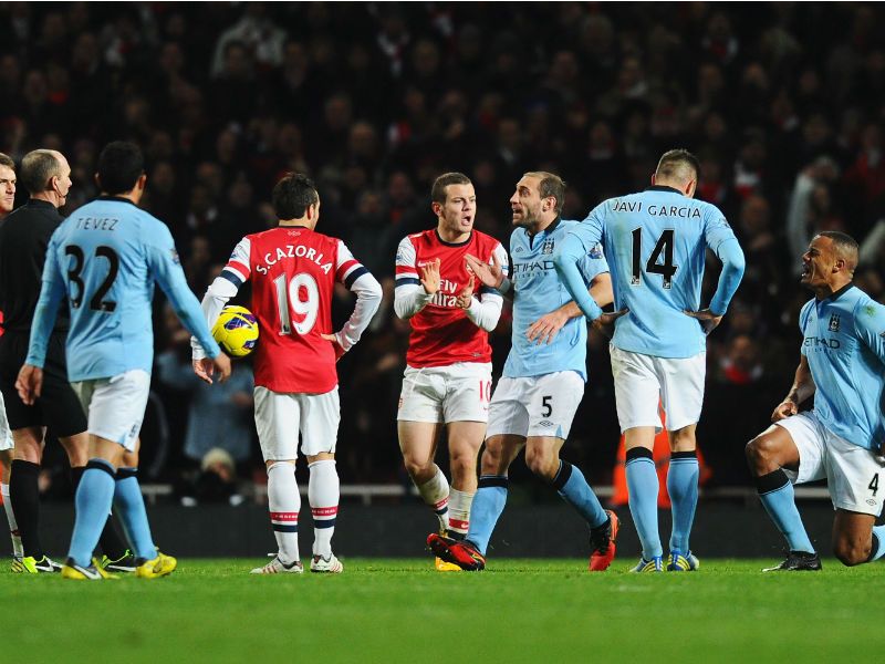 Seeing red: Vincent Kompany is sent off by referee Mike Dean late on for a challenge on Jack Wilshere