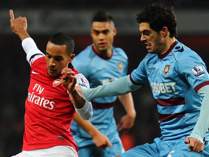 Theo Walcott is put under pressure by James Tomkins during Arsenal's Premier League visit of West Ham at Emirates Stadium.
