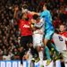 Real Madrid goalkeeper Diego Lopez punches the ball away under pressure from Manchester United players