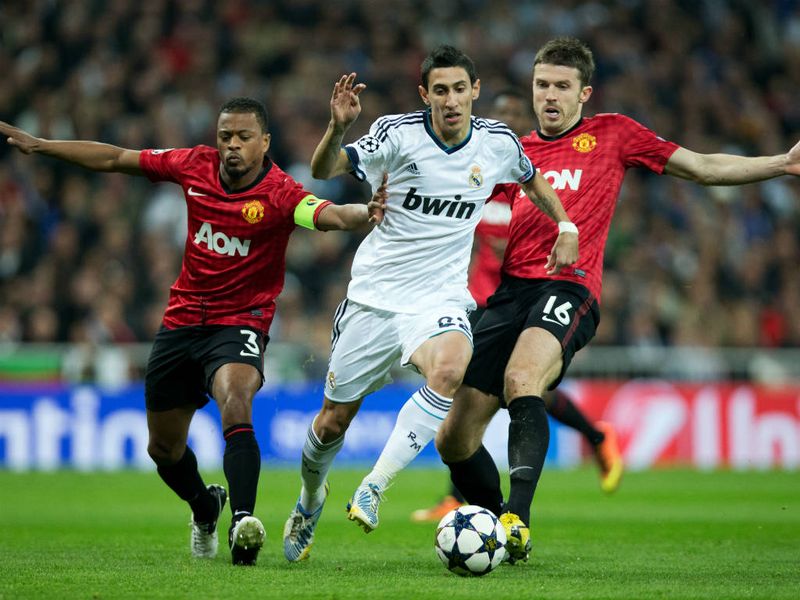 Angel Di Maria is challenged by Manchester United duo Patrice Evra and Michael Carrick
