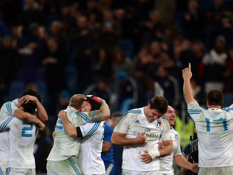 Hugs all around: Italian players cannot believe it as they overcome Les Bleus...