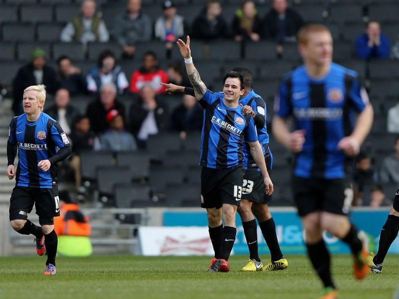 Chris Dagnall points to the sky after opening the scoring for Barnsley at MK Dons