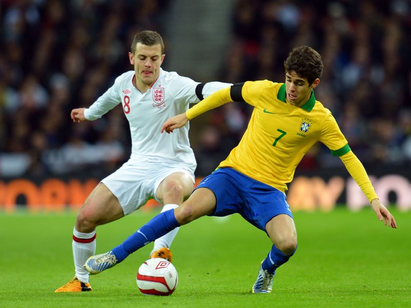 Jack Wilshere and Oscar battle for the ball in midfield