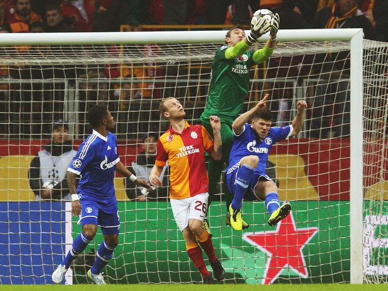 Galatasaray goalkeeper Fernando Muslera takes the ball under pressure from Schalke striker Klaas Jan Huntelaar