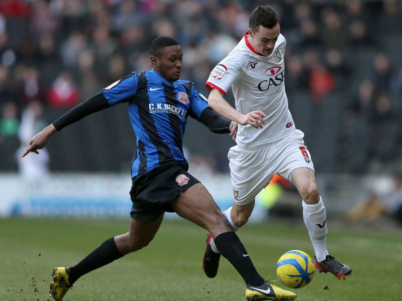Barnsley's Kelvin Etuhu and Shaun Williams of MK Dons compete for the ball