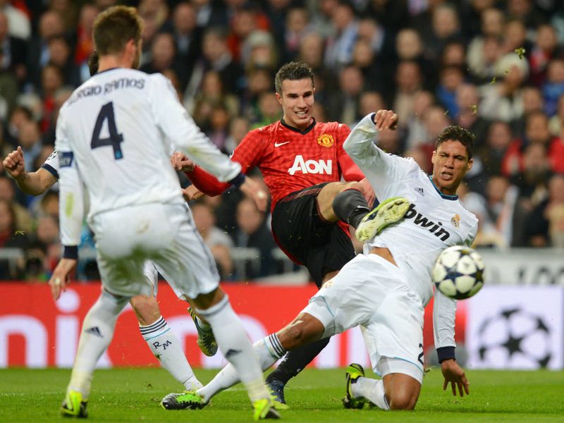 Real Madrid defender Raphael Varane challenges Manchester United striker Robin van Persie