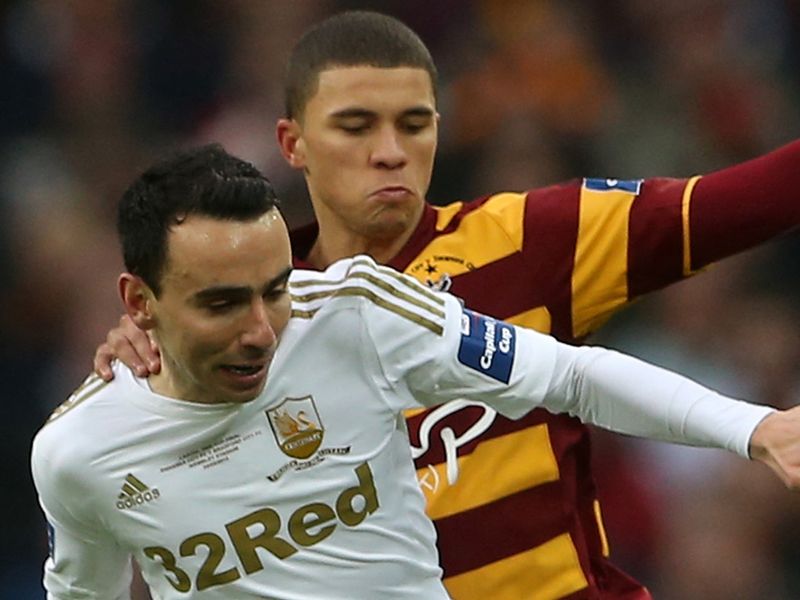 Bradford's Nahki Wells marshals Swansea man Leon Britton on the ball as the clash gets underway