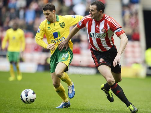 Wes Hoolahan and John O'Shea battle for the ball