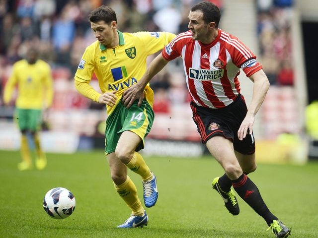Wes Hoolahan and John O'Shea battle for the ball