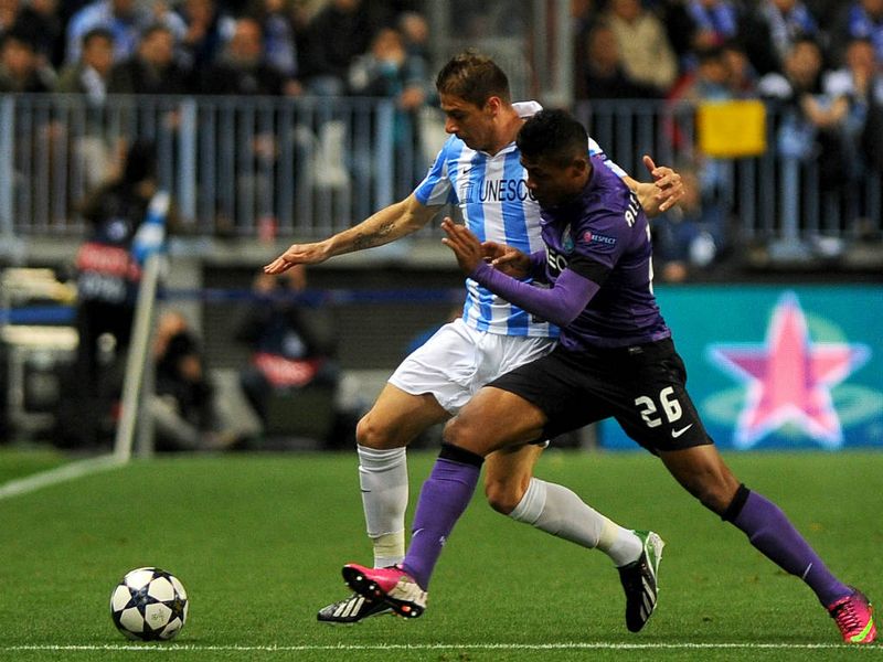 Malaga winger Joaquin and Porto's Alex Sandro tussle for the ball