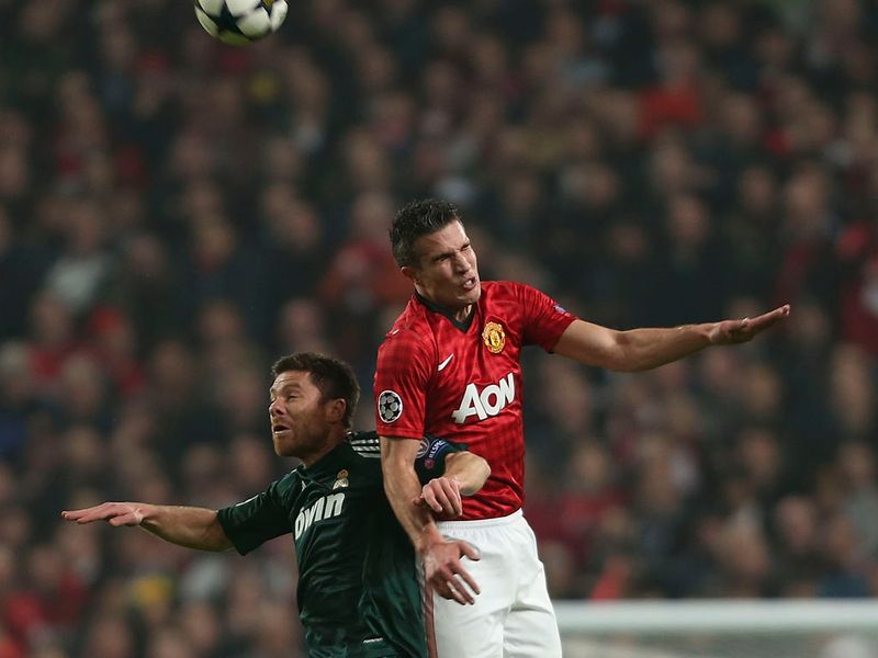 Xabi Alonso and van Persie compete for the ball in the air with the match still goalless after half an hour.