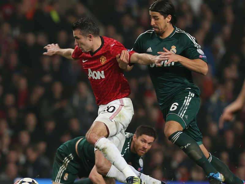 Robin van Persie shields the ball from Sami Khedira as Manchester United try to hold on to their narrow advantage.