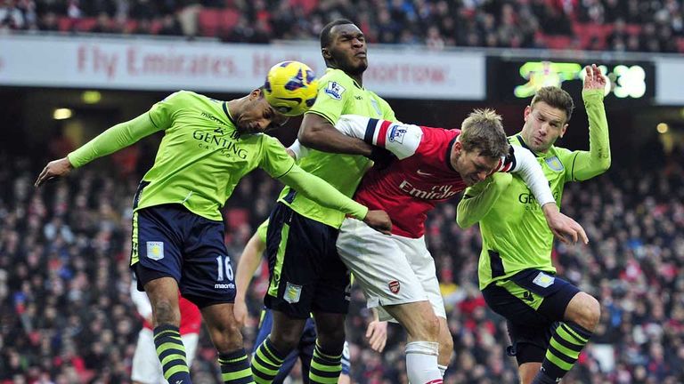 Christian Benteke and Fabian Delph challenge for the ball against Arsenal