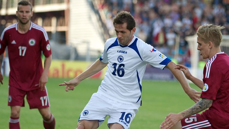 Senad Lulic looks to hold off Latvia's Artis Lazdins