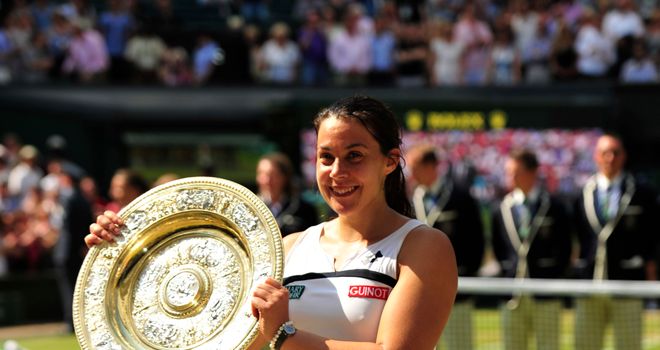 France's Marion Bartoli poses with the winner's Venus Rosewater Dish after beating Germany's Sabine Lisicki in their women's singles final