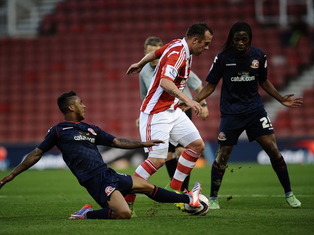 Charlie Adam of Stoke is tackled by Ashley Hemmings