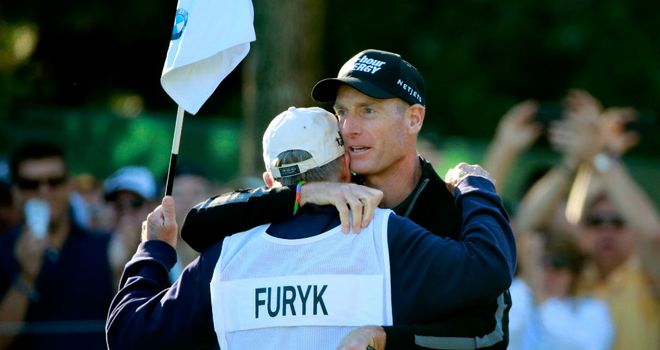 Jim Furyk celebrates with caddie Fluff Cowan after holing out at the ninth