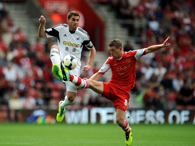 Angel Rangel and Steven Davis battle for the ball