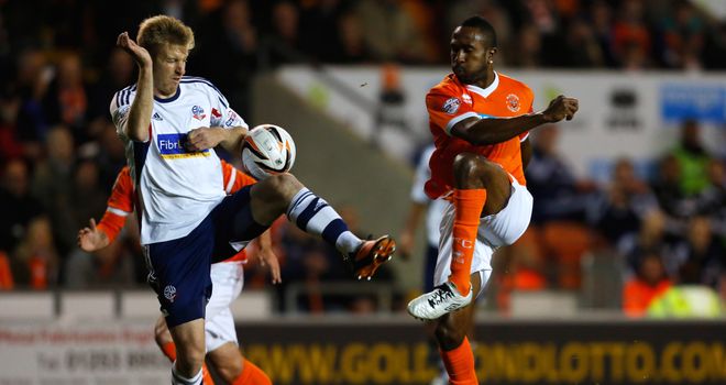 Blackpool's Ricardo Fuller is challenged by Tim Ream of Bolton
